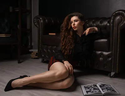 Обои на рабочий стол Девушка с длинными волосами в черной блузке и в  клетчатой юбке сидит на полу комнаты, облокотившись на кресло, фотограф  Илья Баранов, обои для рабочего стола, скачать обои, обои