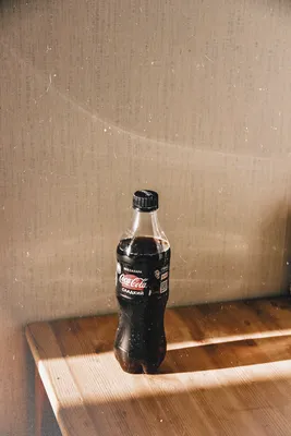 фотография бутылки кока колы на деревянном столе · Бесплатные стоковые фото