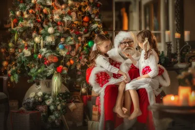 Фото Девочки сидят на руках у Деда Мороза в комнате с елкой. Фотограф  Савченко Кристина