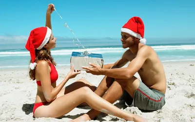 Обои на рабочий стол Девушка с парнем и подарком в новогодних костюмах на  берегу моря, обои для рабочего стола, скачать обои, обои бесплатно