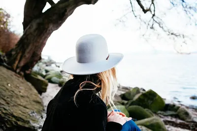 Девушка спиной в шляпе сидит на лавке перед озером — Авы и картинки