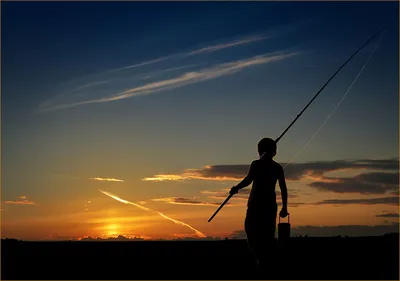 Обои на рабочий стол Силуэт мальчика, держащего в руках удочку и бидончик  для пойманной рыбы, идущего на вечерний клев на фоне золотистого заката c  небольшой облачностью на вечернем небе, фотография Дмитрия Антипова,