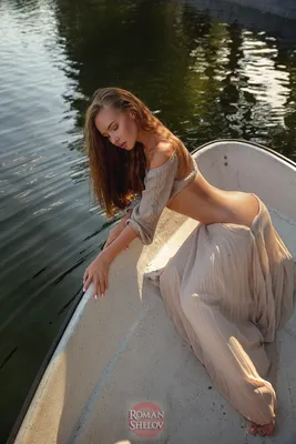 Фото Модель Татьяна Кузнецова с длинными волосами сидит в лодке