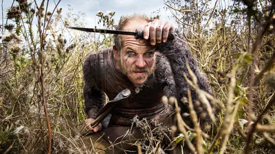 Викинги Густав Скарсгард в роли Флоки, выглядящий злобно, с темными глазами, прижимающий клинок к груди. Фотография 8 x 10 в магазине коллекционных предметов Amazon Entertainment.