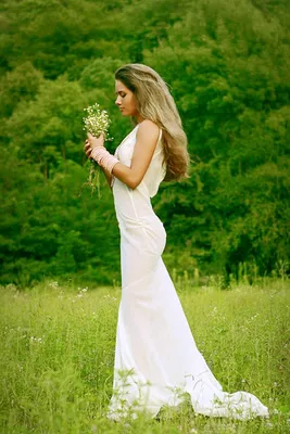 Фото Юлия Паршута, российская певица, актриса, в белом платье держит в  руках букет цветов
