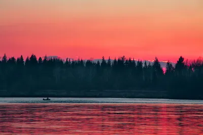 Обои на рабочий стол Мужчина, находящийся в лодке, плывущей по озеру, вышел  на рыбалку на утренней зорьке на фоне багряного неба, отразившегося в  водной поверхности с легкой рябью, фотография Николая Морского, обои