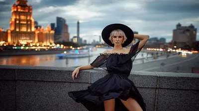 Обои на рабочий стол Модель Тая в шляпе и черном платье позирует, стоя на  мосту, на фоне Москва-реки и огней вечернего города. Фотограф Георгий  Чернядьев, обои для рабочего стола, скачать обои, обои