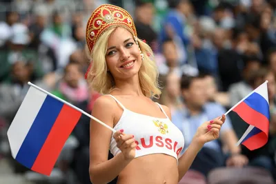 Обои на рабочий стол Девушка Наталья Немчинова - Андреева в кокошнике с  красной надписью Russia на груди и двумя российскими флагами в руках на  фоне людей, обои для рабочего стола, скачать обои,