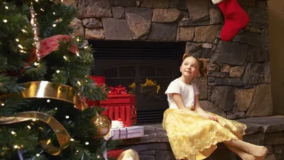 Обои на рабочий стол Девочка, сидящая у камина возле наряженной новогодней  елки, ждет рождественских подарков, обои для рабочего стола, скачать обои,  обои бесплатно