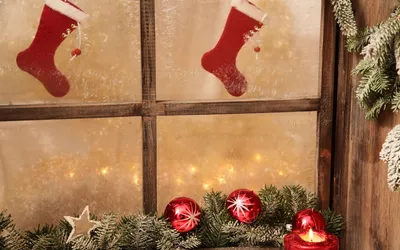 Обои на рабочий стол На покрытом морозными узорами окне висят праздничные  носочки, на подоконнике лежат еловые ветки и красные новогодние шары, обои  для рабочего стола, скачать обои, обои бесплатно