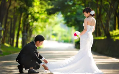 Обои на рабочий стол Жених поправляет невесте подол платья на дорожке в  парке, обои для рабочего стола, скачать обои, обои бесплатно