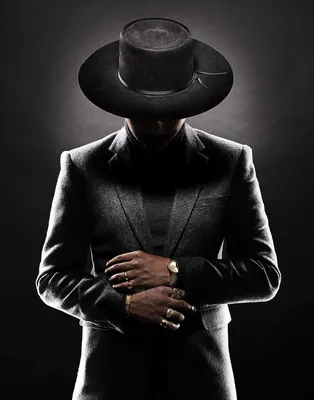 Парень в шляпе стоит в парке с его руками в его карманн Стоковое Фото -  изображение насчитывающей черный, человек: 102659690