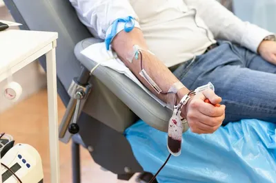 Мужская рука с капельницей, мешок для сбора крови, надувной мяч в блоке  переливания. пожертвование. | Премиум Фото